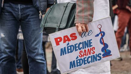 Une pancarte "Pas de médecine sans médecins" lors d'une manifestation de la profession, le 5 janvier 2023, devant le ministère de la Santé, à Paris. (LUC NOBOUT / MAXPPP)