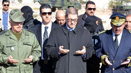 Le Premier ministre tunisien, Habib Essid, en prière au cimetière de Ben Guerdane, le 13 mars 2016, une semaine après l'attaque terroriste contre des casernes de l'armée et de la police, qui avait fait une cinquantaine de morts. (FATHI NASRI/AFP)