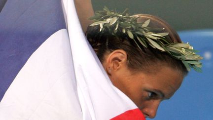 Aux Jeux olympiques d'Ath&egrave;nes, c'est l'explosion : Laure Manaudou d&eacute;croche trois m&eacute;dailles, la moiti&eacute; du bilan de la natation fran&ccedil;aise lors de ces Jeux. C'est aussi la premi&egrave;re m&eacute;daille d'or tricolore depuis Jean Boiteux, en 1952. Suivra une domination de 4 ans. (GERARD JULIEN / AFP)