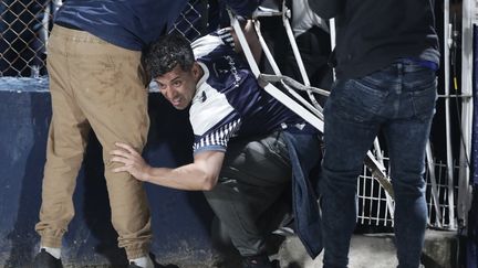 Un supporter de Gimnasia s'extirpe des tribunes à la recherche d'air frais, le 6 octobre 2022. (ALEJANDRO PAGNI / AFP)