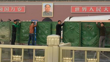 La police installe des barri&egrave;res pour masquer l'endroit o&ugrave; une voiture a explos&eacute; lundi 28 octobre 2013, place&nbsp;Tiananmen, &agrave; P&eacute;kin (Chine). (ED JONES / AFP)