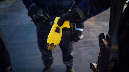 Un gendarme tient un Taser sur un marché de Noël, le 23 décembre 2016, à Tours (Indre-et-Loire). (GUILLAUME SOUVANT / AFP)