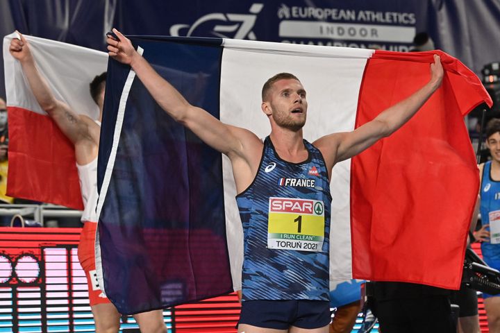 Kevin Mayer brandit le drapeau tricolore le 7 mars 2021 à Torun (Pologne) après son sacre en heptathlon aux championnats d'Europe d'athlétisme. (ANDREJ ISAKOVIC / AFP)