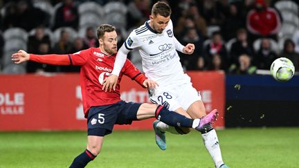 Le Bordelais Remi Oudin et le Lillois Gabriel Gudmundsson&nbsp;au duel lors de la 30e journée de Ligue 1, le 2 avril 2022. (DENIS CHARLET / AFP)