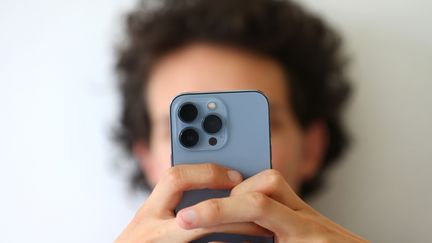 Un homme prend une photo de son visage avec un smartphone. (PICTURE ALLIANCE / PICTURE ALLIANCE via GETTYIMAGES)