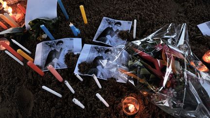 Des fleurs et des bougies sont d&eacute;pos&eacute;es autour de photos de victimes libanaises du crash du vol d'Air Alg&eacute;rie, &agrave; l'a&eacute;roport de Ouagadougou, au Burkina Faso, samedi 26 juillet 2014. (SIA KAMBOU / AFP)