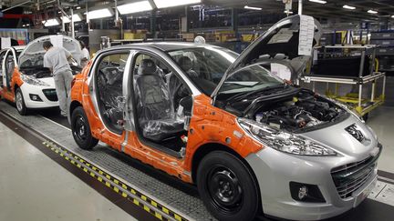 La ligne de production de la nouvelle Peugeot 208 &agrave; l'usine PSA Peugeot-Citro&euml;n de Poissy (Yvelines), le 27 janvier 2012. (THOMAS SAMSON / AFP)