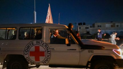 Un véhicule de la Croix-Rouge internationale transportant des otages libérés par le Hamas traverse le poste frontière de Rafah, dans la bande de Gaza, le 24 novembre 2023. (MOHAMMED ABED / AFP)