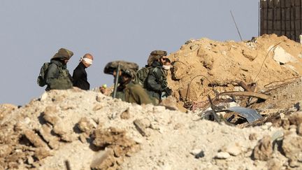 Israeli soldiers alongside blindfolded Palestinians on November 19, 2023 in the Gaza Strip.  (MAHMUD HAMS / AFP)