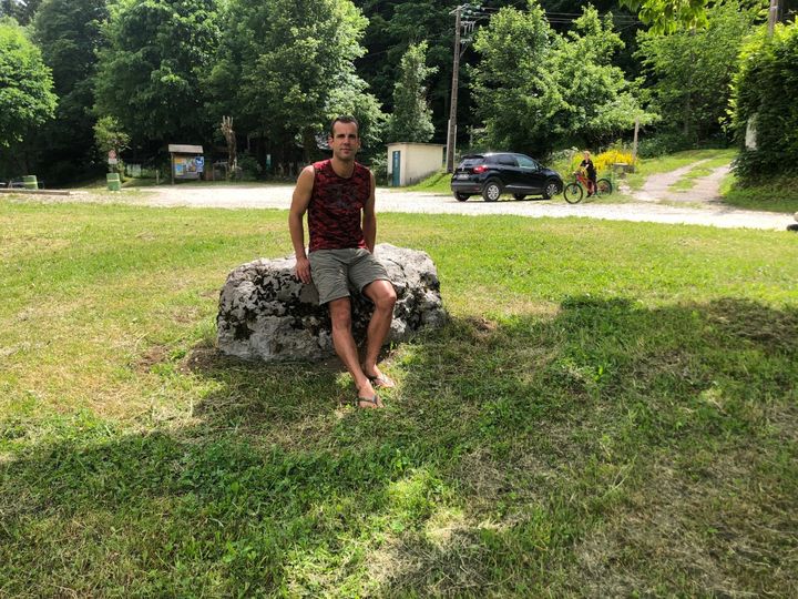 Mickaël, l’un des participants de la "Chartreuse Terminorum", prend la pose sur le "rocher du départ", quelques heures avant la course. (EMMA SARANGO / RADIOFRANCE)