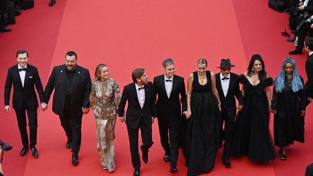 Quelques minutes avant le début de la cérémonie d'ouverture, le président du jury Ruben Östlund (au centre) et les membres du jury se sont tenu la main pour monter les marches. De gauche à droite : l'acteur américain Paul Dano, l'acteur français Denis Ménochet, l'artiste Brie Larson, le président du jury, le réalisateur argentin Damián Szifrón, la réalisatrice française Julia Ducournau, l'écrivain et réalisateur franco-afghan Atiq Rahimi, la réalisatrice Maryam Touzani et la réalisatrice, scénariste et actrice zambienne Rungano Nyoni. (ANTONIN THUILLIER / AFP)