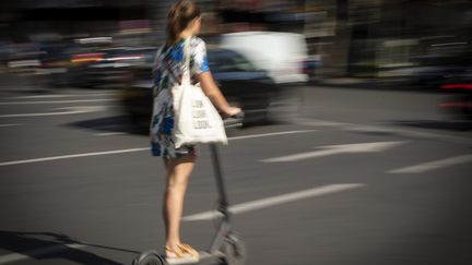 Une jeune femme utilisant une trottinette&nbsp;à Paris en septembre 2018.&nbsp; (ALEXIS SCIARD  / MAXPPP)