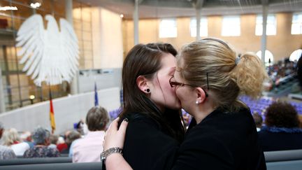 Deux femmes s'embrassent au Bundestag, la chambre basse du Parlement allemand, à Berlin, après le vote par cette dernière d'une loi autorisant le mariage pour tous, le 30 juin 2017. (FABRIZIO BENSCH / REUTERS)