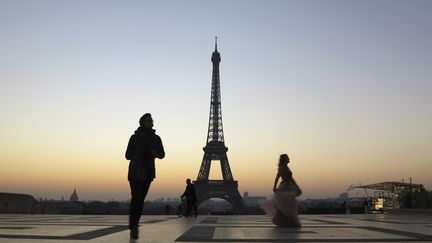 Des passants circulent devant la tour Eiffel, sur la place du Trocadéro, le 20 janvier 2017.&nbsp; (LUDOVIC MARIN / AFP)