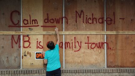 Une habitante peint "Calme-toi Michael" avant l'arrivée de l'ouragan en Floride, le 9 octobre 2018. (JOE RAEDLE / GETTY IMAGES NORTH AMERICA)