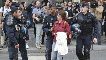 Des policier évacuent une opposante, pendant une manifestation en marge d'un meeting pro-Loi Travail, à Paris, le 8 juin 2016. (JACQUES DEMARTHON / AFP)