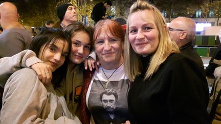 Christine (centre) est venue en famille à la Fnac des Champs-Elysées,&nbsp;exceptionnellement ouverte dans la nuit du 19 octobre, pour être l'une des premières à écouter le nouvel&nbsp;et dernier album de son idole Johnny Hallyday. (ALICE SERRANO / RADIO FRANCE)