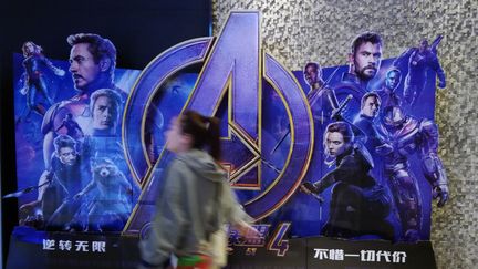 Une femme passe devant une pancarte promotionnelle pour le film "Avengers : Endgame" dans un un cinéma de Yichang, en Chine, le 13 mai 2019. (YI CHANG / IMAGINECHINA / AFP)