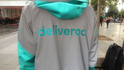 Un livreur Deliveroo de dos, à Paris, en 2017. (LAURINE BENJEBRIA / FRANCE-INFO)