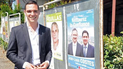 Le candidat FN&nbsp;Etienne Bousquet-Cassagne pose devant l'affiche &eacute;lectorale de son adversaire UMP Jean-Louis Costes, le 16 juin 2013, &agrave; Villeneuve-sur-Lot (Lot-et-Garonne). (MEHDI FEDOUACH / AFP)