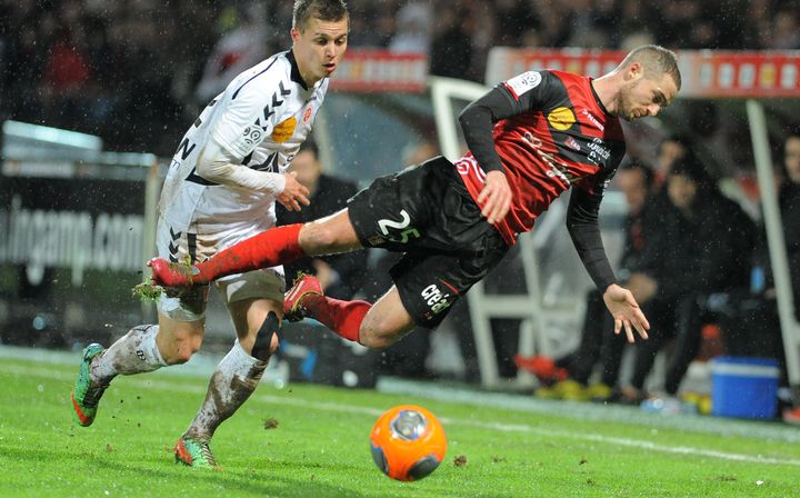 Le d&eacute;fenseur guingampais Reynald Lema&icirc;tre glisse devant l'attaquant r&eacute;mois Nicolas de Pr&eacute;ville, lors du match Guingamp-Reims, le 8 f&eacute;vrier 2014.&nbsp; (FRED TANNEAU / AFP)