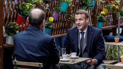 Le président de la République, Emmanuel Macron, partage un café avec le Premier ministre, Jean Castex, le 19 mai 2021, sur une terrasse parisienne. (GEOFFROY VAN DER HASSELT / AFP)