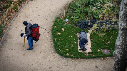 Un sans-abri dort dans un parc public, le 1er octobre à Paris. (JOEL SAGET / AFP)