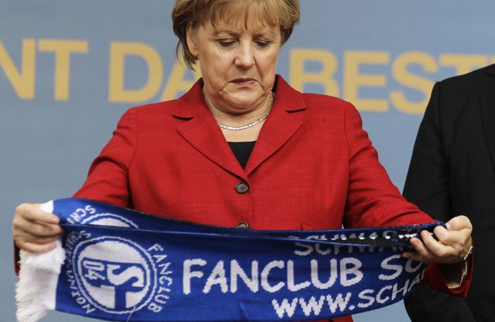 La chanceli&egrave;re allemande Angela Merkel d&eacute;couvre une &eacute;charpe aux couleurs de Schalke 04, le 9 mai 2012.&nbsp; (WOLFGANG RATTAY / REUTERS)