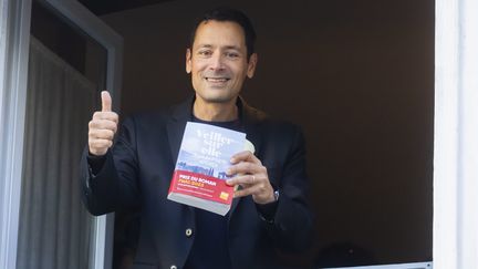 L'écrivain Jean-Baptiste Andrea à la fenêtre du restaurant Drouant, à Paris, lors de la réception de son prix Goncourt pour son roman "Veiller sur elle", le 7 novembre 2023. (VINCENT ISORE / MAXPPP)