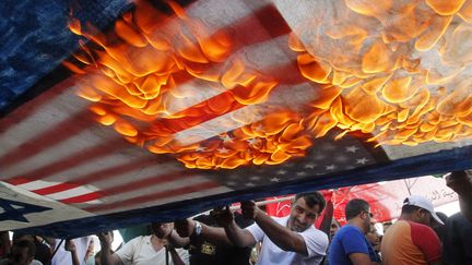 Des Libanais et des Palestiniens br&ucirc;lent des drapeaux am&eacute;ricains et isra&eacute;liens pour protester contre les frappes a&eacute;riennes sur la bande de Gaza &agrave; Sidon (Liban), le 10 juillet 2014. (ALI HASHISHO / REUTERS)