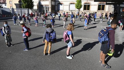 Des élèves font la queue avant d'entrer en classe, à l'école élémentaire&nbsp;Ziegelau à Strasbourg (Bas-Rhin), le 22 juin 2020. (FREDERICK FLORIN / AFP)