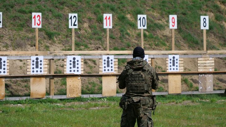 In front of the shooting range, Aleksandr holds his rifle.  His main motivation was to combine civilian and military life.  In civilian life?  he works in the Institute of National Memory, an institution which investigates Nazi and communist crimes.  A job related to his role as a soldier, according to him.  (MARTIN CHABAL / RADIOFRANCE)