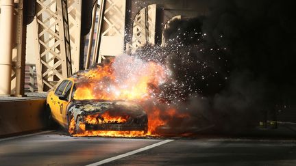 Un taxi new-yorkais en feu sur le 59th Street Bridge &agrave; New York (Etats-Unis), le 9 janvier 2013. (ERIK PENDZICH / REX / SIPA)