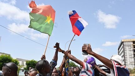 Des manifestants tiennent le drapeau burkinabé et le drapeau russe, le 4 octobre 2022, à Ouagadougou (Burkina Faso), après le coup d'état du capitaine Ibrahim Traoré.&nbsp; (ISSOUF SANOGO / AFP)