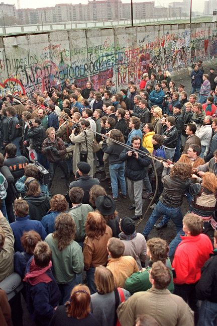 Des Ouest-Berlinois tentent de faire tomber une section du Mur, près de Potsdamer Platz, le 11 novembre 1989. (GERARD MALIE / AFP)