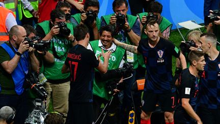 Les joueurs Mario Mandzukic et Ivan Rakitic s'enquièrent de la santé du photographe Yuri Cortez, submergé par les joueurs lors d'une célébration de but lors de la demi-finale entre la Croatie et l'Angleterre, le 11 juillet 2018 à Moscou (Russie). (MLADEN ANTONOV / AFP)