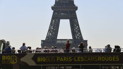 Des touristes prennent en photo la tour Eiffel, en août 2018. (ALAIN JOCARD / AFP)