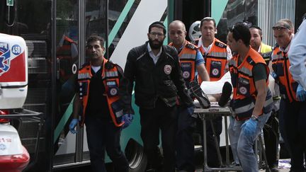 Des secouristes isra&eacute;liens transportent un corps sur une civi&egrave;re le 13 octobre 2015, &agrave; J&eacute;rusalem-Est, apr&egrave;s une attaque contre un bus. (GALI TIBBON / AFP)