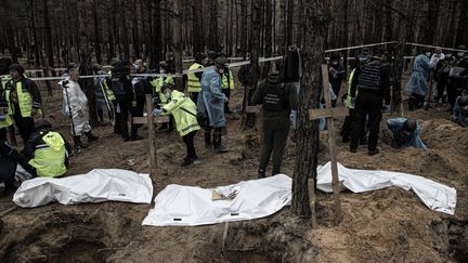 Les autorités ukrainiennes exhument des corps enterrés à Izioum, dans l'Est de l'Ukraine,&nbsp;le 16 septembre 2022. (METIN AKTAS / ANADOLU AGENCY / AFP)