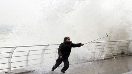 Un homme se prend en photo sur la corniche de Beyrouth (Liban) pendant une temp&ecirc;te, le 11 f&eacute;vrier 2015. (MOHAMED AZAKIR / REUTERS)