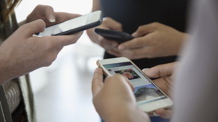 Utilisateurs de téléphones mobiles. (HERO IMAGES VIA GETTY IMAGES)