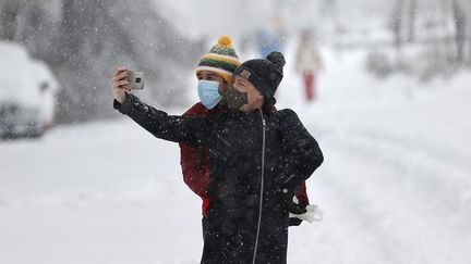 Deux personnes se photographient durant la tempête Filomena à Madrid, le 9 janvier 2021. (BURAK AKBULUT / ANADOLU AGENCY / AFP)