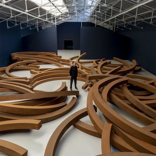 Le sculpteur Bernar Venet au centre de son oeuvre "L'hypothèse de la gravité" exposée au Louvre-Lense (Le Louvre-Lens)