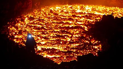 Un homme près du volcan&nbsp;Klyuchevskoy, en Russie, le 16 mars 2021. (MAXIM FESYUNOV / AFP)