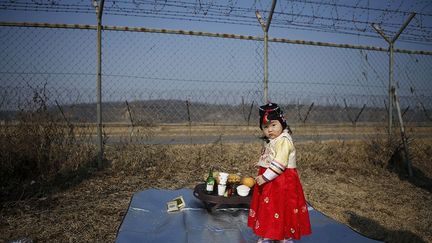 une fillette en costume traditionnel coréen devant une clôture à Paju, ville frontalière près de la zone démilitarisée séparant les deux Corée. Lors de Seollal, le Nouvel an coréen, les familles rendent hommage à leurs ancêtres en se prosternant et en préparant des plats particuliers.
 
 (REUTERS/Kim Hong-Ji)