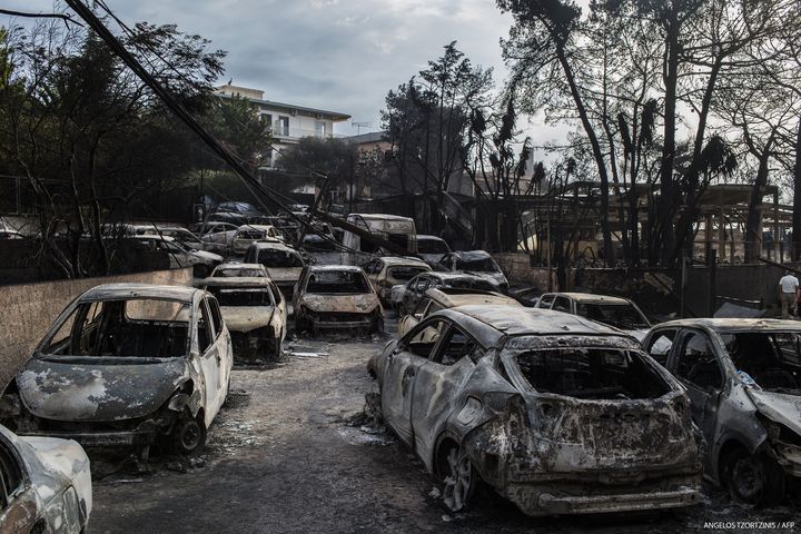 Des voitures brulées à Mati, en Grèce, après un incendie, le 24 juillet 2018.&nbsp; (ANGELOS TZORTZINIS / AFP)