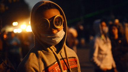 Un manifestant se prot&egrave;ge des gaz lacrymog&egrave;nes, pr&egrave;s de la place Tahrir, au Caire (Egypte), le 28 janvier 2013. (KHALED DESOUKI / AFP)