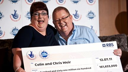 Colin Weir et son épouse posent avec le chèque remporte à l'Euromillion en Ecosse, le 15 juillet 2011. (WATTIE CHEUNG / AFP)