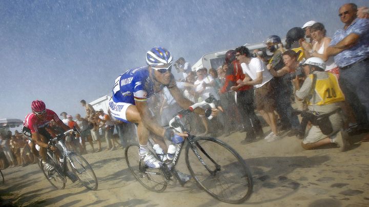 Le coureur belge Tom Boonen (en bleu) se fraie un chemin dans la poussi&egrave;re des pav&eacute;s de Paris-Roubaix, le 15 avril 2007. (FRANCK FIFE / AFP)