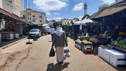 Un homme marche devant les&nbsp;étals du marché de Jénine, le 13 avril 2022. (FREDERIC METEZEAU / RADIO FRANCE)